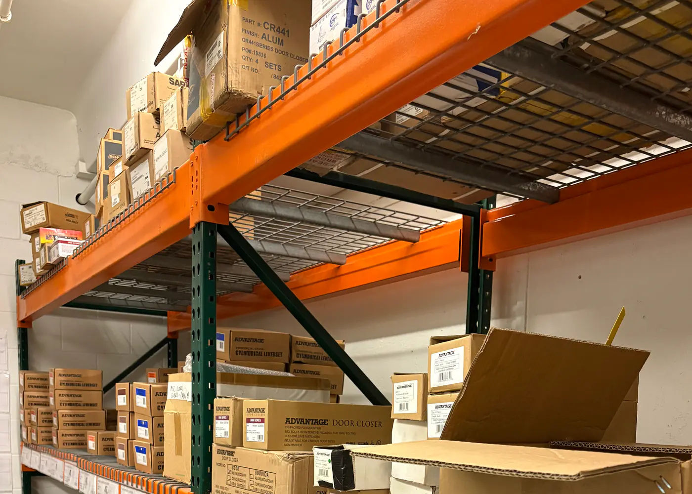 Commercial door closers and locksets stocked on warehouse shelving