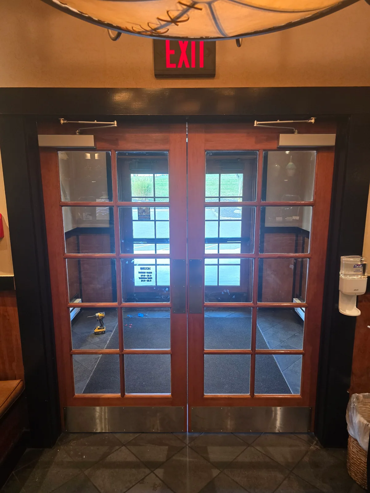 Architectural wood double doors with multiple vision lites, overhead closers, and kick plates