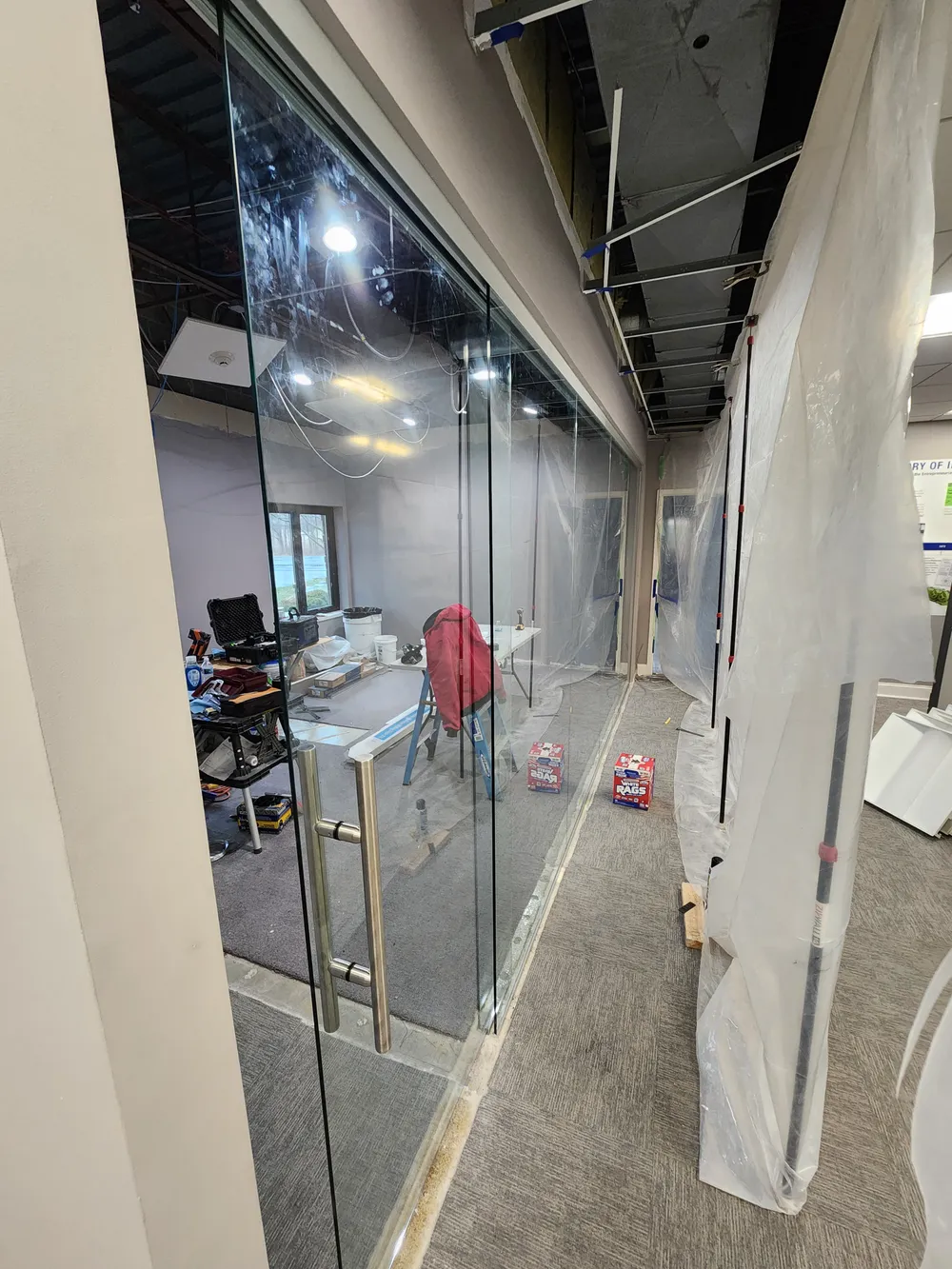 Floor-to-ceiling interior glass partitions and a glass door in a commercial office renovation