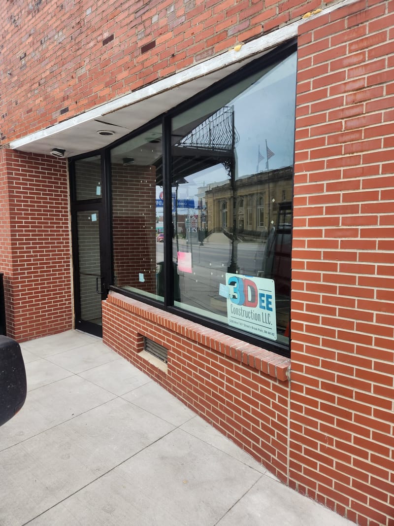 Dark bronze aluminum storefront windows and entrance in a brick facade - Lorain, OH