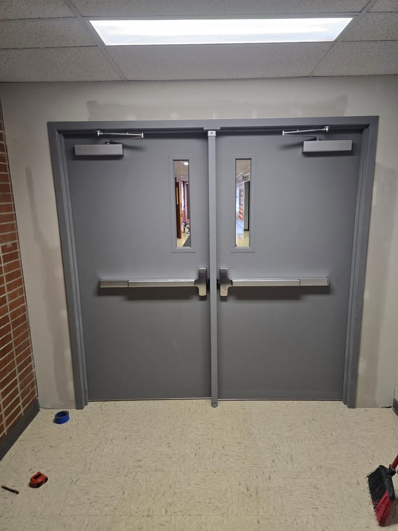 Pair of hollow metal doors with narrow lites, exit devices, and a center mullion - Oberlin, OH