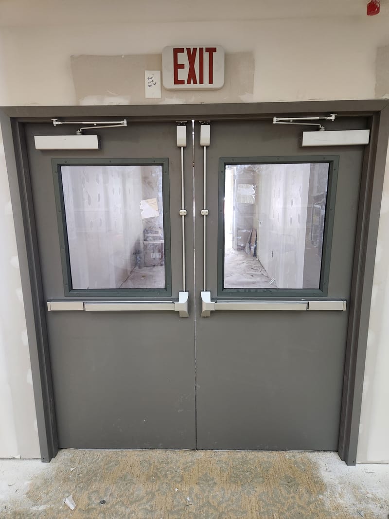 Hollow metal double doors with half glass lites and vertical rod exit devices - Bellevue, OH