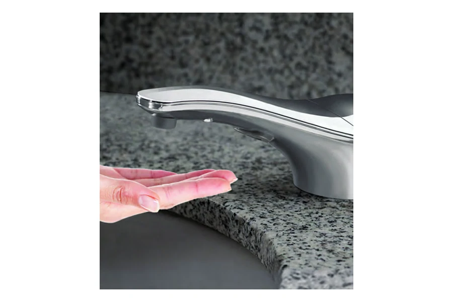 Automatic counter-mounted soap dispenser beside a commercial restroom sink