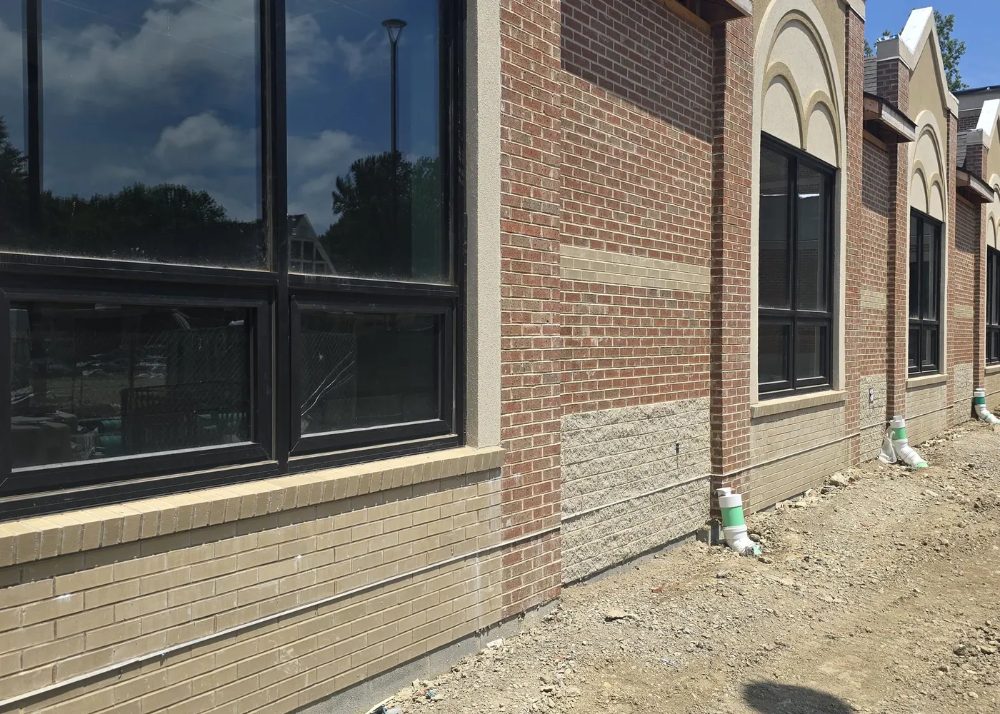 Black aluminum storefront framing and glass windows on a commercial brick building
