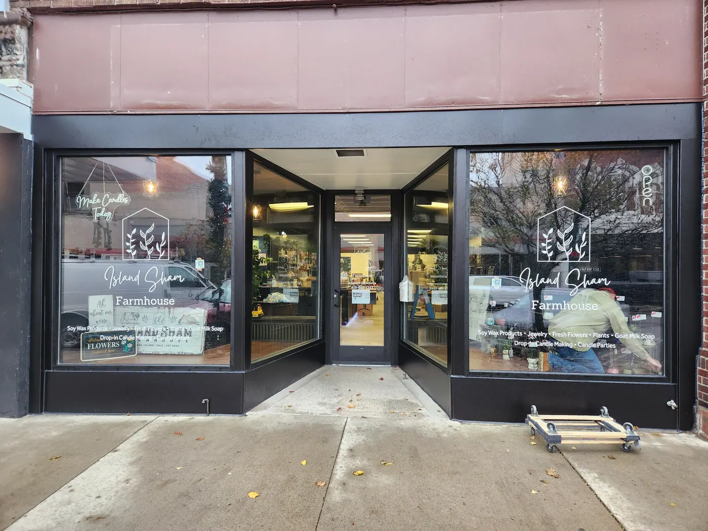 Black aluminum retail storefront with large display windows and a recessed glass entrance door